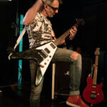 Guitarist performing live at The 13th Floor during Push Push concert, showcasing energetic stage pre.