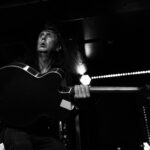 Guitarist performing passionately during a Push Push concert at The 13th Floor venue.