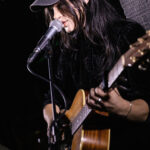 Harper Finn performing guitar and singing at The 13th Floor during a concert.