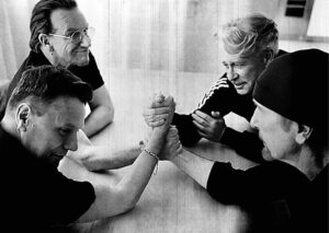 U2 arm wrestling match at The 13th Floor, celebrating music and friendship.